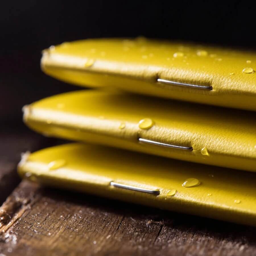 close up of pile of stapled waterproof notebooks