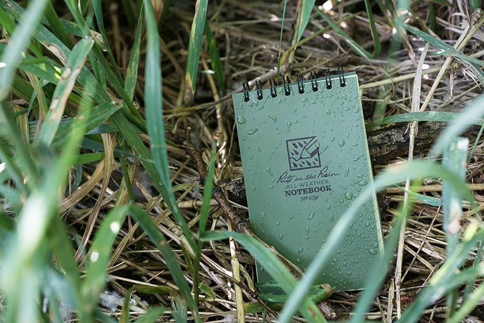 waterproof pocket notebook placed amongst long grass