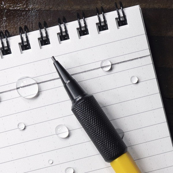 waterproof pen placed on top of waterproof notebook with water droplets