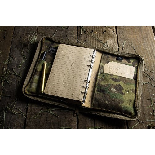 Waterproof notebook in cordura ring binder placed on a rustic wooden background