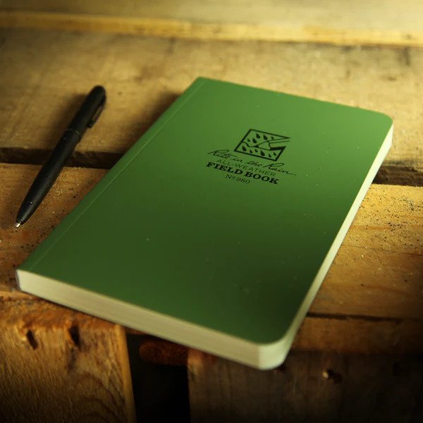 waterproof field notebook with pen placed on a wooden table