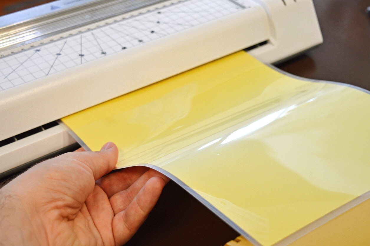 person laminating yellow sheets of people